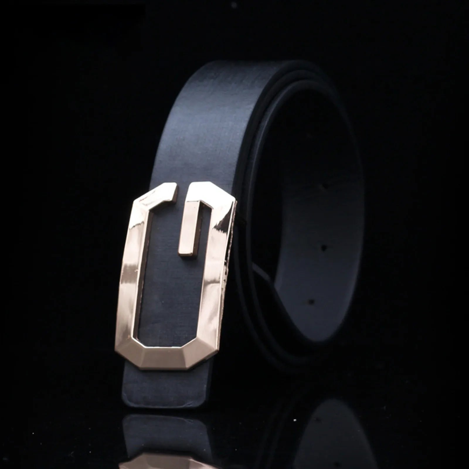Black belt with a gold buckle on a black background