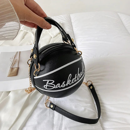Black basketball-shaped handbag with 'Basketball' text on a white surface