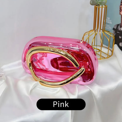 Pink Carauana Festival Clutch Bag with gold accents on a white surface