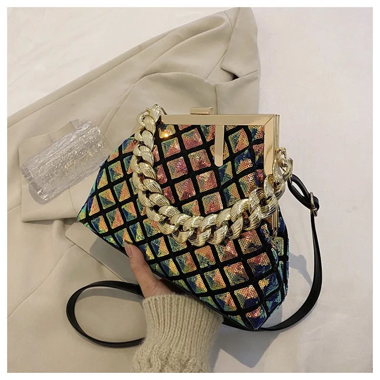 Colorful patterned handbag with a gold chain handle held by a person wearing a beige sweater.