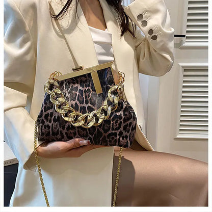 Person holding a Carauana_UNIU_Leopard_Clutch with gold chain detail