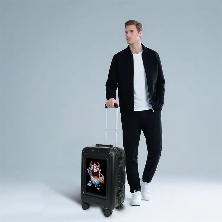 Man holding a black suitcase with a digital display on a gray background