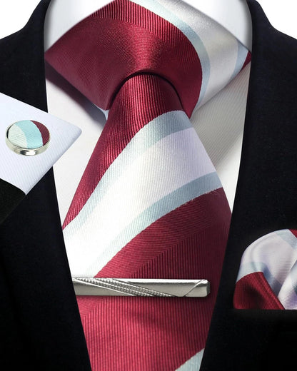 Red and white striped tie with matching pocket square and tie clip on a black suit.