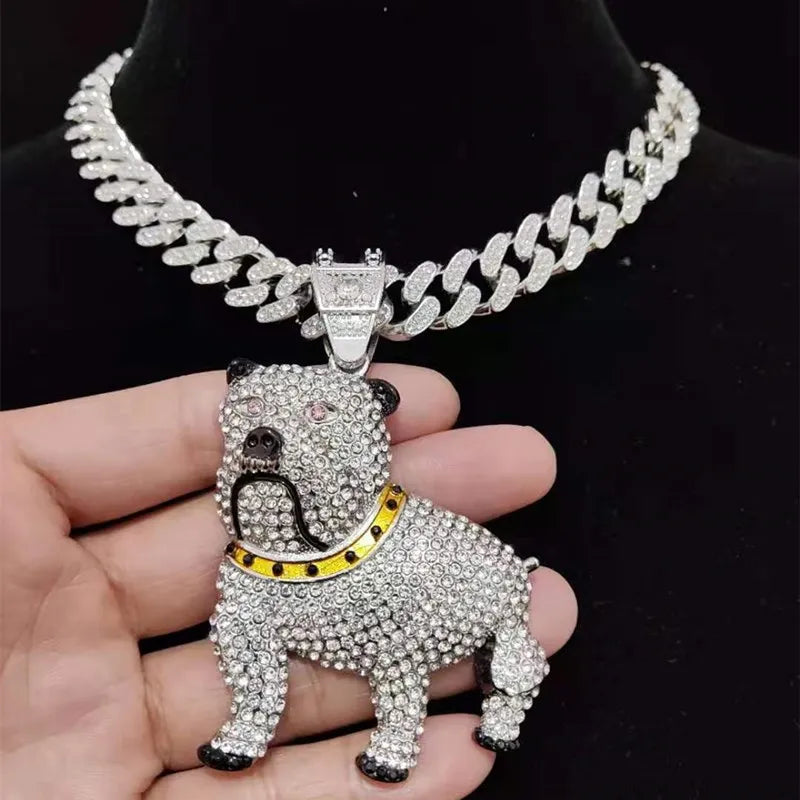Silver bulldog pendant necklace with clear stones on a hand against a black background